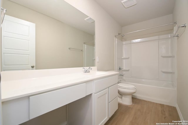 full bathroom with shower / bathing tub combination, vanity, hardwood / wood-style flooring, and toilet