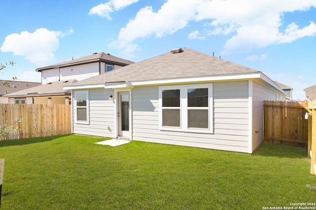 rear view of property featuring a yard