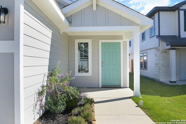 entrance to property featuring a lawn