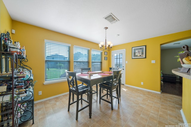 tiled dining area featuring a chandelier