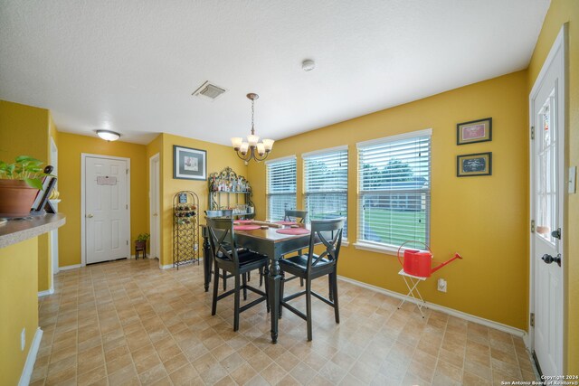 tiled dining room with an inviting chandelier