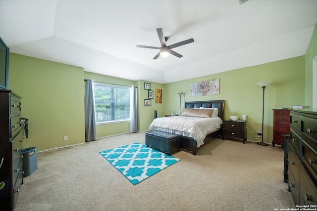 carpeted bedroom with ceiling fan and a tray ceiling