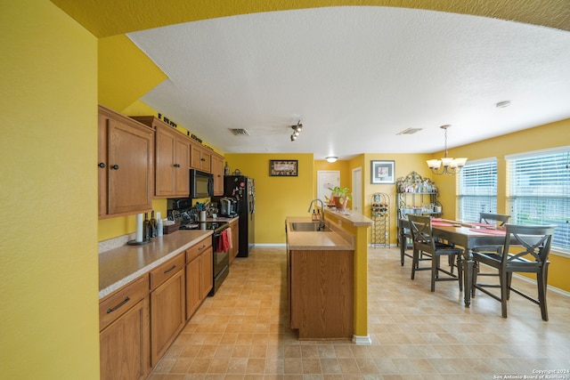 kitchen with light tile flooring, decorative light fixtures, black appliances, a notable chandelier, and sink