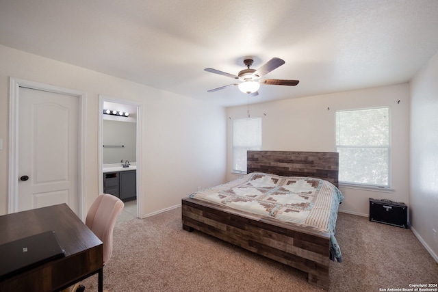 bedroom featuring connected bathroom, ceiling fan, sink, and light colored carpet