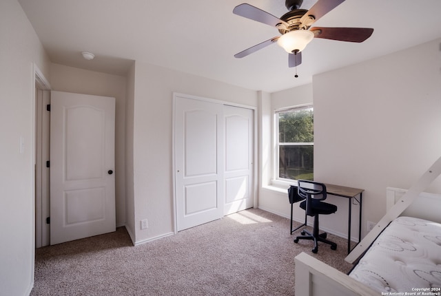 bedroom featuring light colored carpet, a closet, and ceiling fan