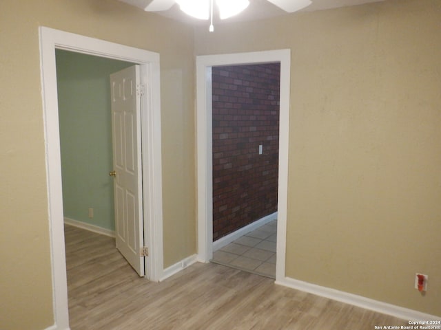 interior space with light hardwood / wood-style flooring and brick wall