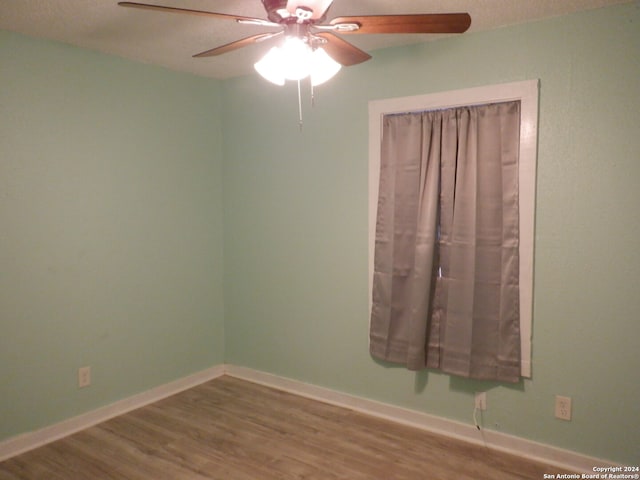 empty room featuring ceiling fan, hardwood / wood-style floors, and a textured ceiling