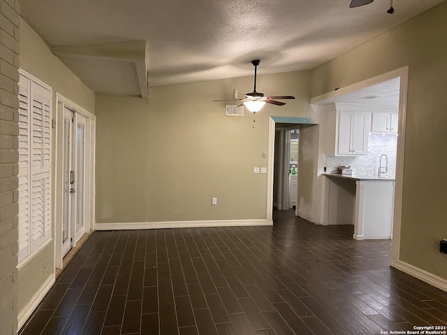 unfurnished living room with a textured ceiling, ceiling fan, dark wood-type flooring, and sink