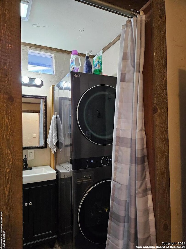 laundry room featuring stacked washer / dryer and sink