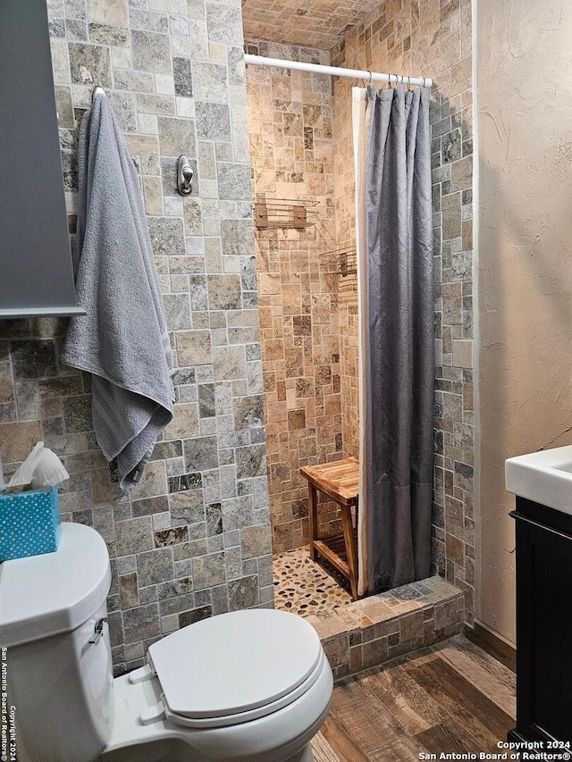 bathroom with walk in shower, vanity, toilet, and hardwood / wood-style flooring