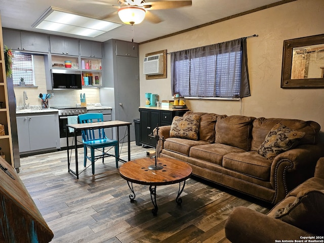 living room with ceiling fan, light hardwood / wood-style floors, and sink