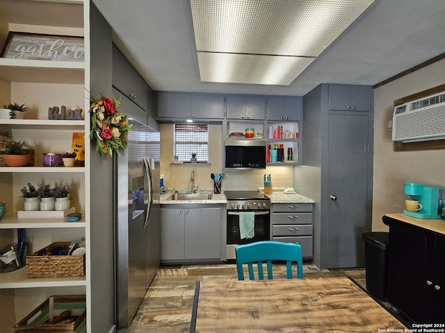 kitchen featuring an AC wall unit, sink, gray cabinetry, and stainless steel appliances