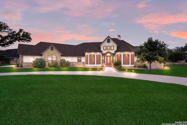 french provincial home featuring a lawn