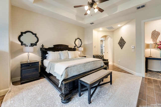 bedroom featuring ceiling fan and a raised ceiling