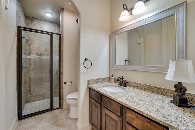 bathroom with tile patterned floors, toilet, vanity, and walk in shower