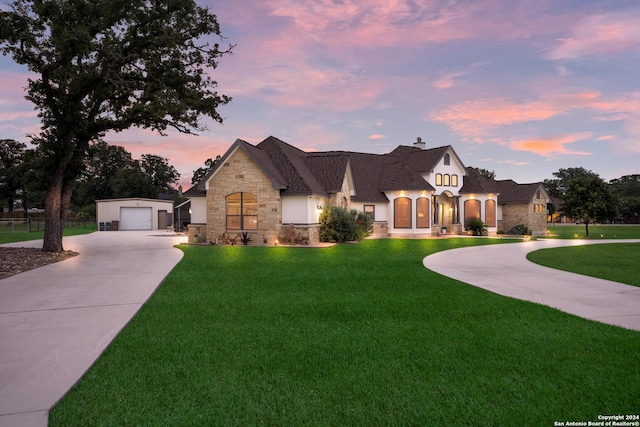 view of front of home featuring an outbuilding, a garage, and a lawn