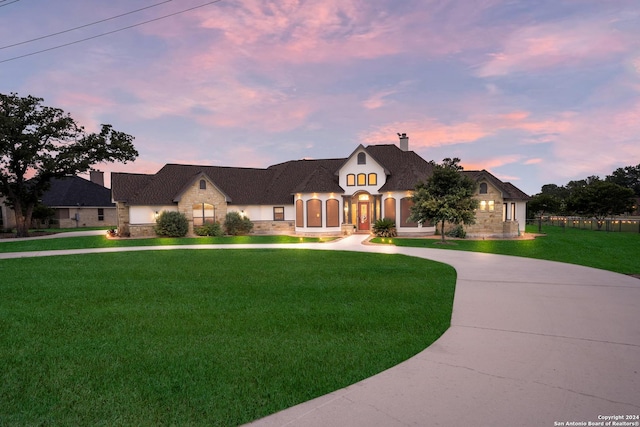 french provincial home with a lawn