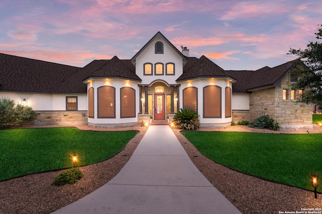 french country home featuring a yard