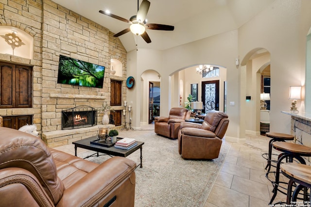 living room featuring ceiling fan, light tile patterned floors, a fireplace, and high vaulted ceiling