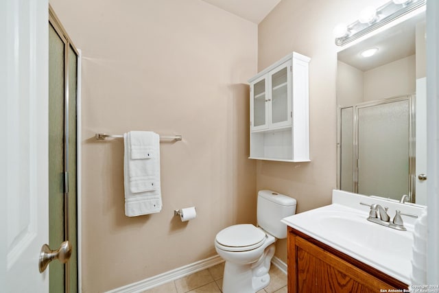 bathroom featuring tile patterned flooring, vanity, a shower with shower door, and toilet