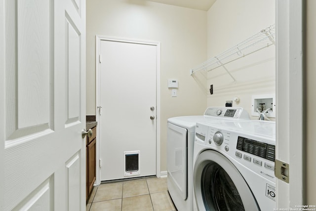 washroom with washing machine and clothes dryer and light tile patterned floors