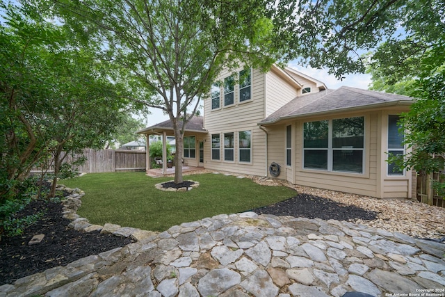 rear view of house featuring a yard and a patio area