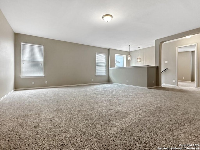 unfurnished room with carpet and an inviting chandelier