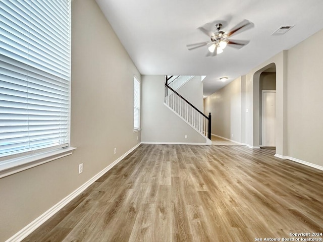 unfurnished living room with plenty of natural light, ceiling fan, and light hardwood / wood-style flooring