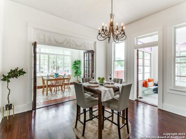 dining space with dark hardwood / wood-style flooring, plenty of natural light, and a notable chandelier