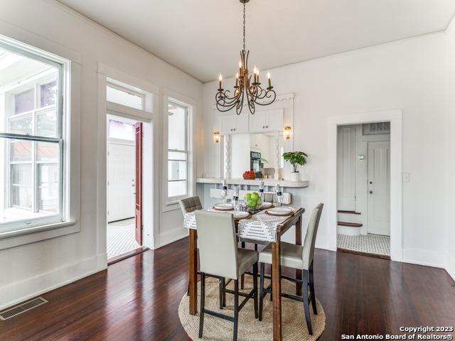 dining space with dark hardwood / wood-style flooring and an inviting chandelier