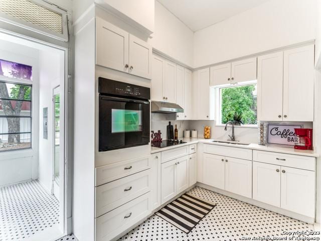 kitchen featuring sink, white cabinets, and black appliances