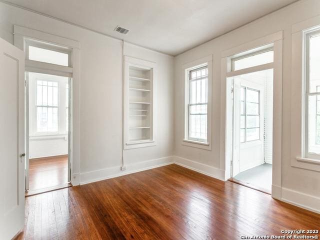 interior space with wood-type flooring, built in features, and plenty of natural light