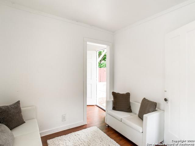 living room with dark hardwood / wood-style flooring and crown molding