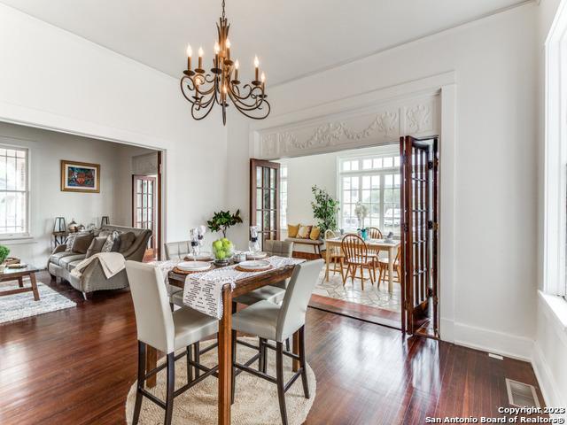 dining area featuring french doors, dark hardwood / wood-style floors, and a notable chandelier