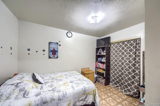 bedroom with light hardwood / wood-style flooring and a textured ceiling