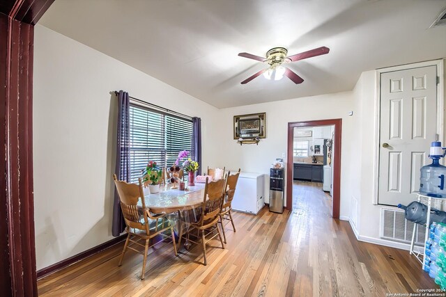 kitchen featuring washer / dryer, stainless steel refrigerator, light hardwood / wood-style flooring, backsplash, and a textured ceiling