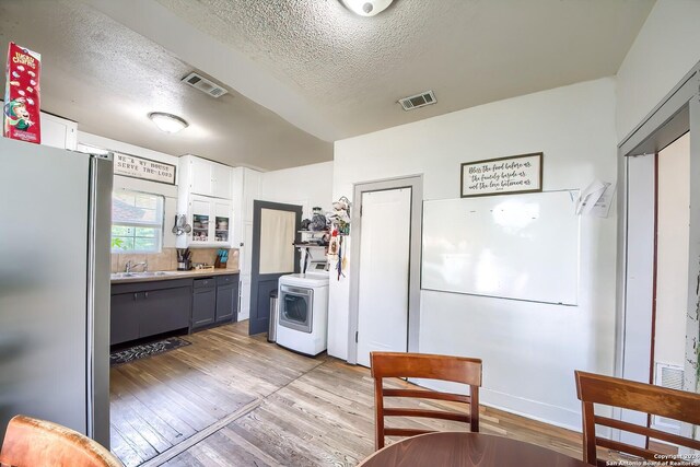 kitchen featuring a wealth of natural light, appliances with stainless steel finishes, a textured ceiling, and hardwood / wood-style floors