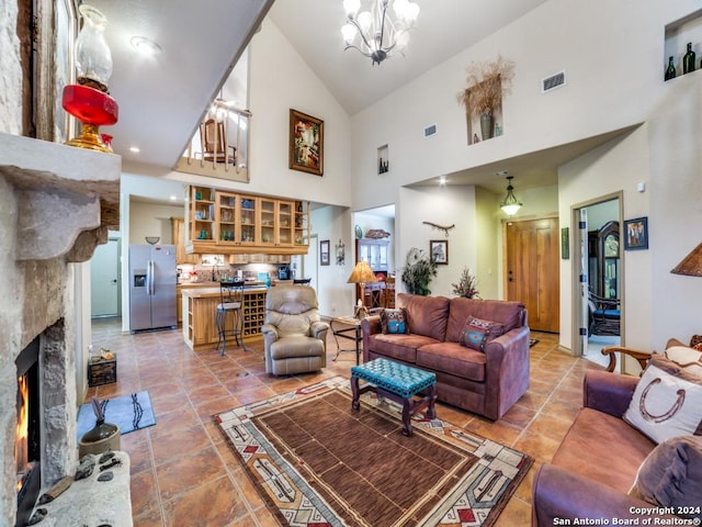 living room with a chandelier, a fireplace, lofted ceiling, and visible vents