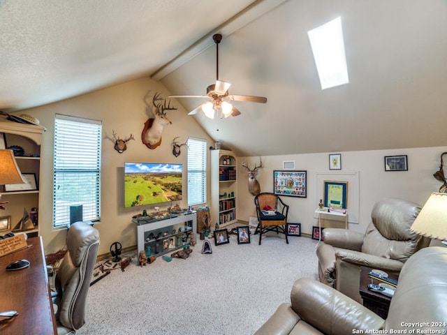 carpeted living room with a ceiling fan, vaulted ceiling with skylight, and a textured ceiling