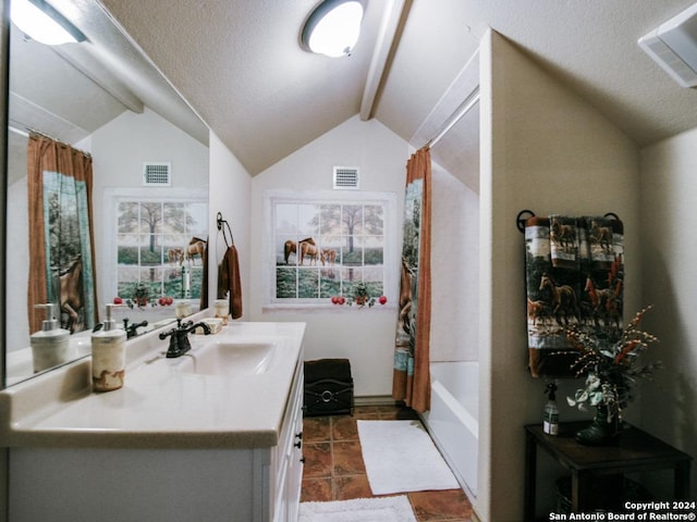 full bathroom with visible vents, vaulted ceiling with beams, vanity, and a textured ceiling