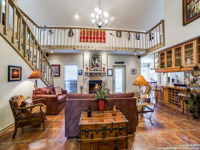 living area featuring a large fireplace, a high ceiling, a chandelier, and a wealth of natural light