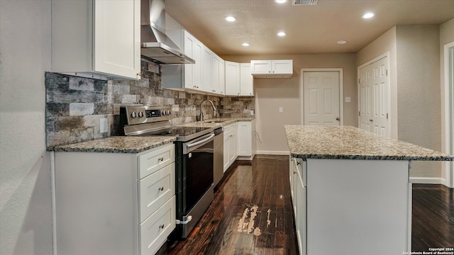 kitchen featuring white cabinets, a kitchen island, stainless steel electric range oven, and wall chimney exhaust hood