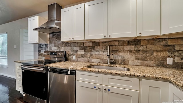 kitchen with backsplash, white cabinets, sink, wall chimney exhaust hood, and appliances with stainless steel finishes