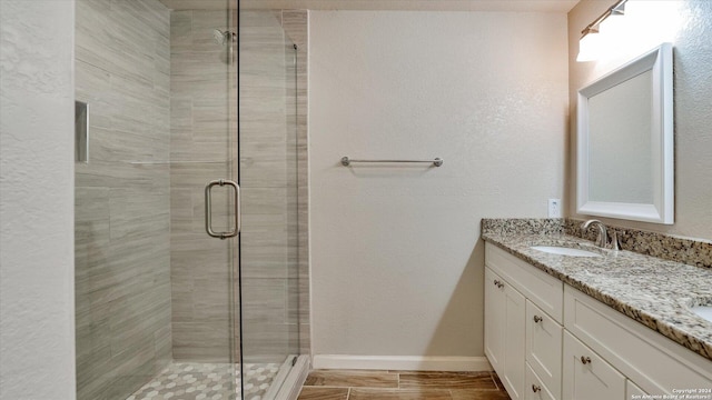 bathroom featuring vanity and a shower with door