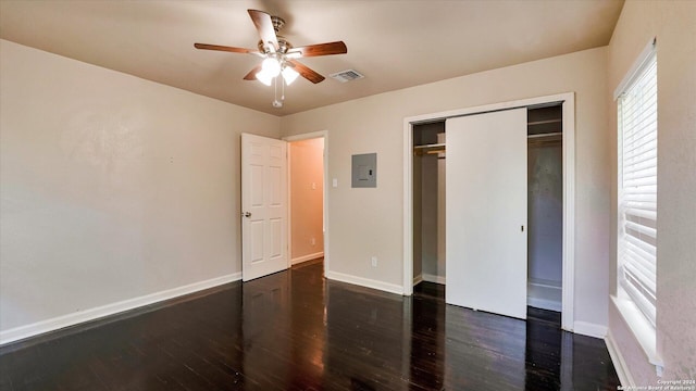 unfurnished bedroom with a closet, dark hardwood / wood-style flooring, electric panel, and ceiling fan