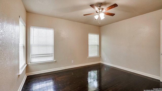 empty room featuring ceiling fan, dark hardwood / wood-style flooring, and plenty of natural light