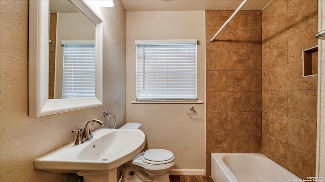 full bathroom with toilet, sink, and tiled shower / bath