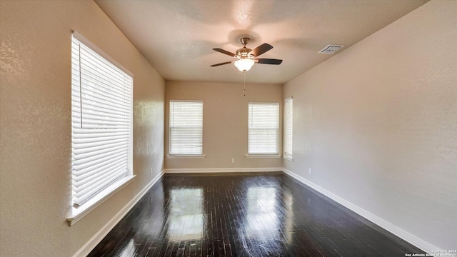 empty room with ceiling fan and dark wood-type flooring