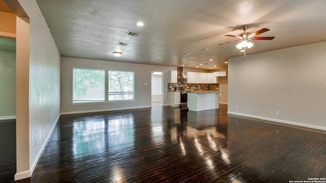 unfurnished living room with a textured ceiling, dark hardwood / wood-style floors, and ceiling fan