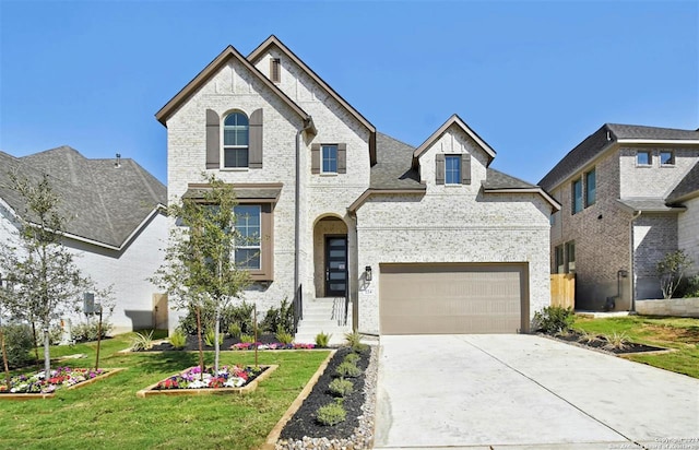 french provincial home with a front lawn and a garage